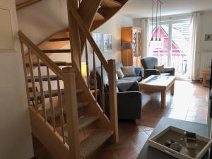 uma sala de estar com uma escada em espiral e uma sala de estar em Glebbe 66 _ Hus Suennschien em Zingst