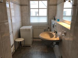uma casa de banho com um lavatório, um WC e uma janela. em Glebbe 66 _ Hus Suennschien em Zingst