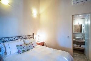 1 dormitorio con cama blanca y lavamanos en Apolis Deluxe Villa, en Agios Georgios