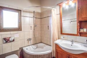 Un baño con ducha, bañera y lavabo. en Apolis Luxury Villa, en Agios Georgios 12 fotos más