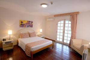 a bedroom with a bed and a couch at Colonial Plaza Hotel Pindamonhangaba in Pindamonhangaba