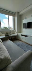 un soggiorno con divano e TV di Recanto Terraneo-Gramado a Gramado