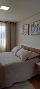 una camera con un grande letto e una finestra di Recanto Terraneo-Gramado a Gramado