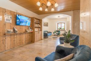 a living room with blue chairs and a tv at BSW Hotel Hubertus-Park in Schönau am Königssee