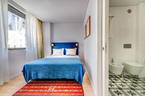 a bedroom with a blue bed and a bathroom at LSA Liberdade by Numa in Lisbon