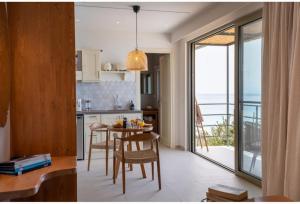 a kitchen with a table and chairs and a balcony at Thea Suites in Lourdhata