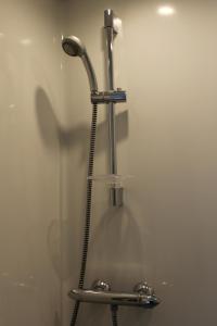y baño con ducha y cabezal de ducha. en Hôtel et Restaurant de la Gare Torigny-les-Villes, en Torigni-sur-Vire