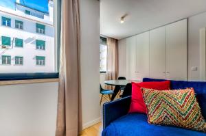 リスボンにあるリスボン サービスアパートメント リベルダーデのリビングルーム(青いソファ、窓付)