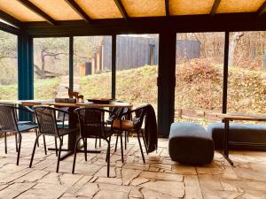 a patio with a table and chairs and a large window at Shambhala centrum in Lúčka