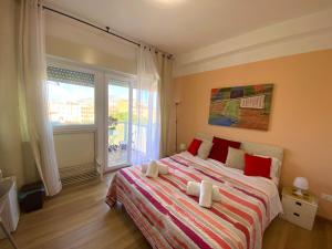 a bedroom with a bed with red pillows and a window at LeAlbe di Sicilia in Palermo