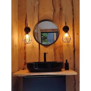 LúčkaにあるShambhala centrumの黒い洗面台と鏡のあるバスルーム