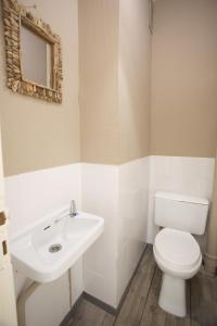 uma casa de banho com um WC branco e um lavatório. em Hossegor - Plage 100m - Surf - Famille - Couple em Soorts-Hossegor
