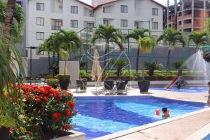 une piscine dans un hôtel avec un enfant qui y joue dans l'établissement Veredas do Rio Quente Family, à Rio Quente