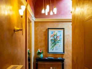 a hallway with a painting and a vase of flowers at Apartments am Glockenspielplatz in Graz