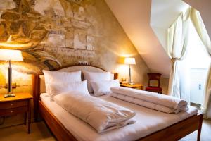 1 cama con sábanas blancas y almohadas en una habitación en Apartments am Glockenspielplatz, en Graz