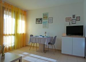 a living room with a table and a television at Studio Apartment Michelle - Intermezzo with sea view in Rabac