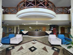 a lobby with blue and white chairs and a bar at Colonial Plaza Hotel Pindamonhangaba in Pindamonhangaba