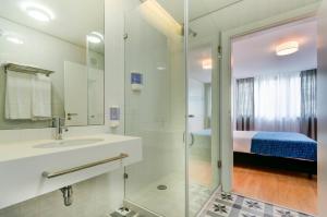 a bathroom with a shower and a sink and a bed at LSA Liberdade by Numa in Lisbon +49 photos