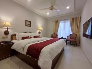Un dormitorio con una cama grande y una ventana en Welcome Hotel Islamabad en Islamabad