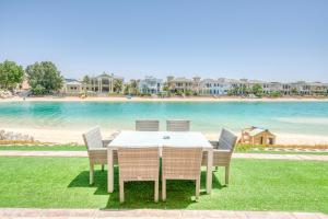 einen Tisch und Stühle mit Blick auf den Strand in der Unterkunft Stunning Villa with Private Pool & Beach Access in Dubai