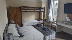 a bedroom with two bunk beds and a desk at Dalgair House Hotel in Callander