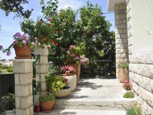 a patio with potted plants and flowers in pots at Apartments Profaca in Rab