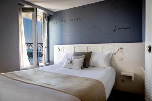 a bedroom with a large white bed with a map on the wall at Hotel Atlantique in Le Palais