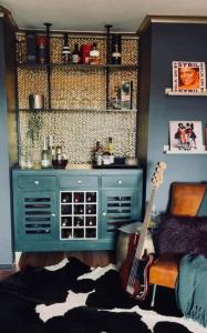 uma sala com um armário azul e uma guitarra em The Tranquil Traveller em Sunbury