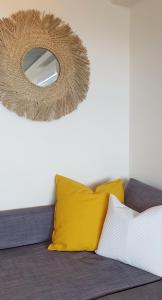 a mirror on top of a couch with yellow pillows at Holiday Home SLAVIA NEW 807 z widokiem na morze in Międzyzdroje