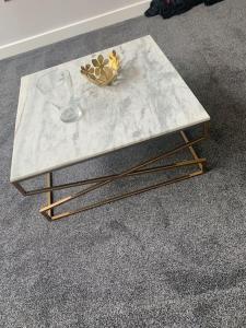 a marble coffee table with a wine glass on it at 3 bedroom barn conversion in the country (Pet Friendly) in Stawell