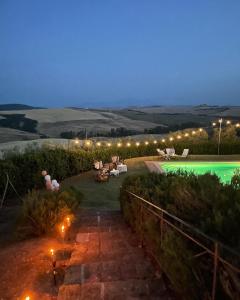 a backyard with a swimming pool at night at Agriturismo Bombina in Montisi