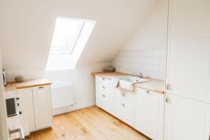 uma cozinha branca com um lavatório e uma janela em Ferienwohnung Stylo 2.0 em Celle