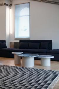 ein Wohnzimmer mit 2 Tischen und einem Sofa in der Unterkunft BasicVillage Milano in Mailand