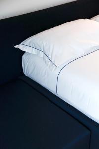 łóżko z białą pościelą i poduszkami w obiekcie BasicVillage Milano w Mediolanie