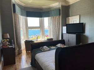 a bedroom with a bed and a large window at Ardmhor Guest House in Oban