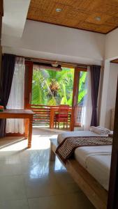 a bedroom with two beds and a large window at Ubud Dream in Ubud