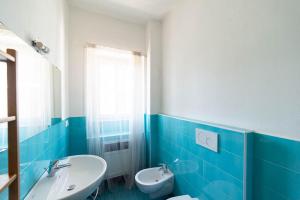 ミラノにあるCorso Como A12の青と白のバスルーム(洗面台、トイレ付)
