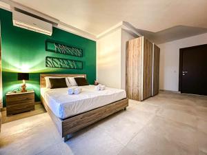 - une chambre avec un grand lit et un mur vert dans l'établissement Kunsu's Apartment 5 min walk from St Julians, à San Ġwann