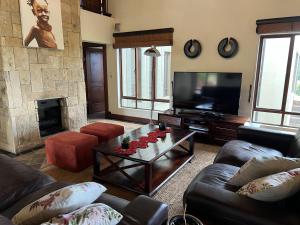 a living room with a couch and a table and a television at 211 Zebula in Mabula