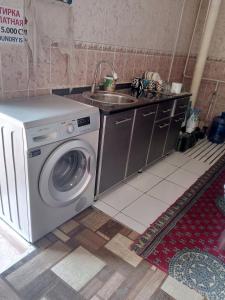 a kitchen with a washing machine and a sink at Hotel Sohibqiron Boutique in Bukhara