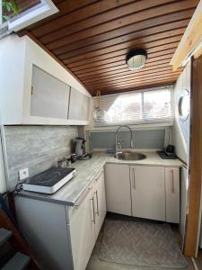 a small kitchen with white cabinets and a sink at Bateau Fellowship in Narbonne +12 photos