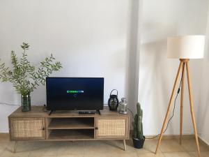 een tv op een houten standaard naast een lamp bij Alexandra Villa in Balíon