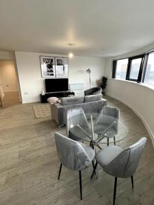 sala de estar con sofá, mesa y sillas en Luxurious City View Apartment in Salford, en Mánchester