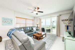 a living room with a couch and a ceiling fan at Unit 102 Aruba - 3 Bedroom Ocean Front in Daytona Beach