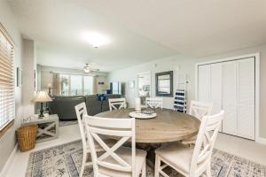 uma sala de jantar e sala de estar com mesa e cadeiras em Unit 102 Aruba - 3 Bedroom Ocean Front em Daytona Beach