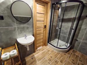 a bathroom with a sink and a shower at Noclegi Rezydent Polańczyk in Polańczyk
