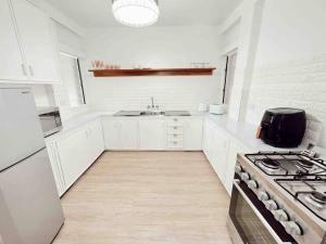 a white kitchen with a stove and a sink at Gladestone Gem 2 - Suva CBD - 2bd Apt in Suva