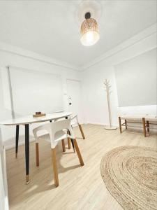 a white room with a table and a white chair at Gladestone Gem 2 - Suva CBD - 2bd Apt in Suva
