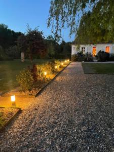 a gravel driveway with lights in front of a house at Domaine de La Vove in Corbon