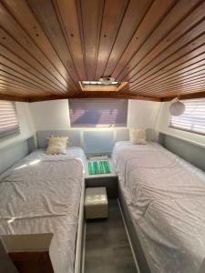two beds in a small room with two windows at Bateau Fellowship in Narbonne